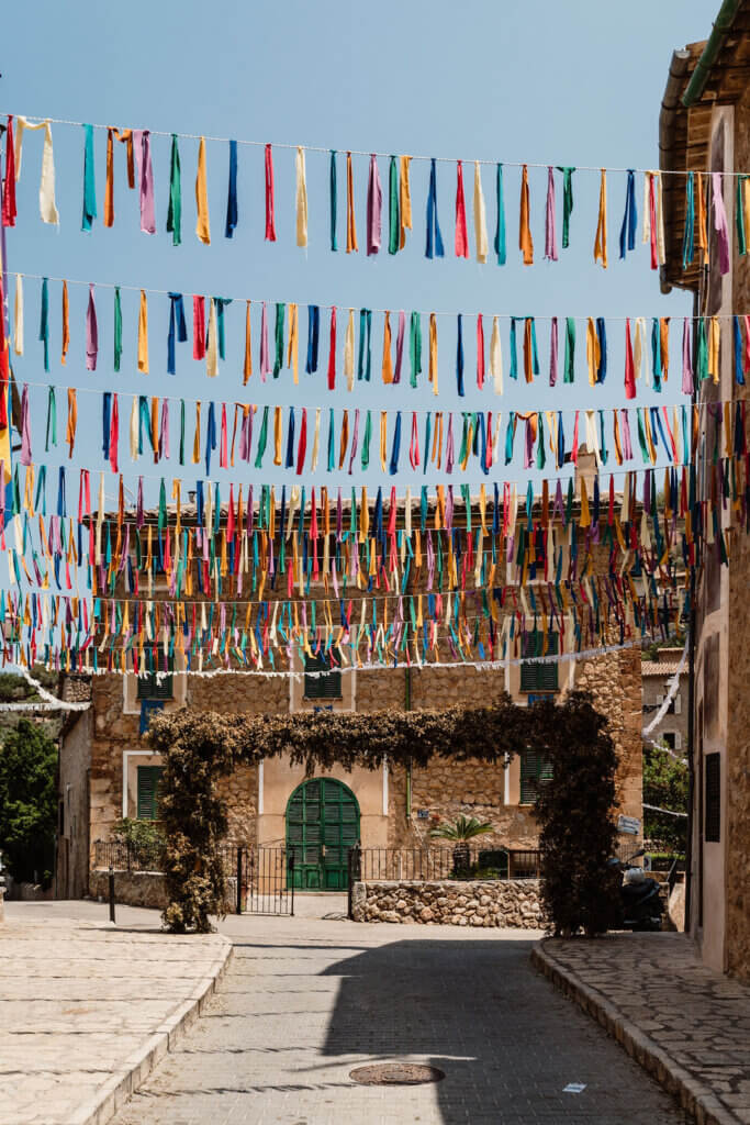 Deia Mallorca village street decorated with colorful festival ribbons