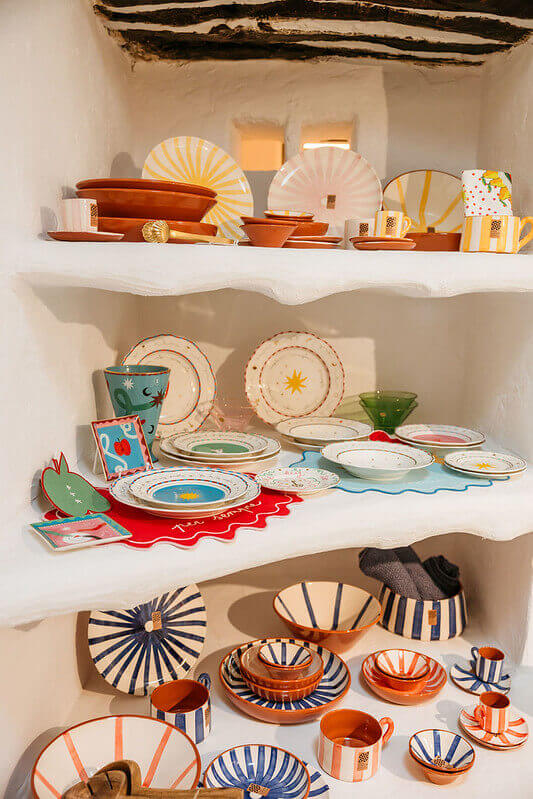 Colorful handmade ceramics and tableware displayed on shelves in Ibiza, Spain
