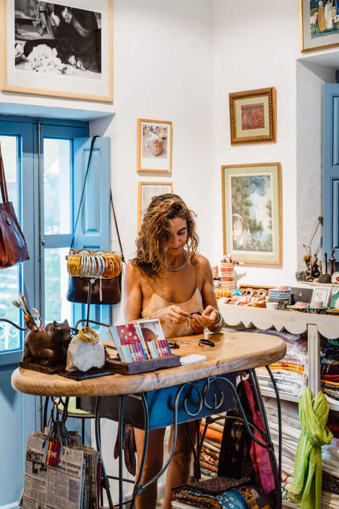 Woman browsing handmade crafts and textiles inside a local shop in Ibiza