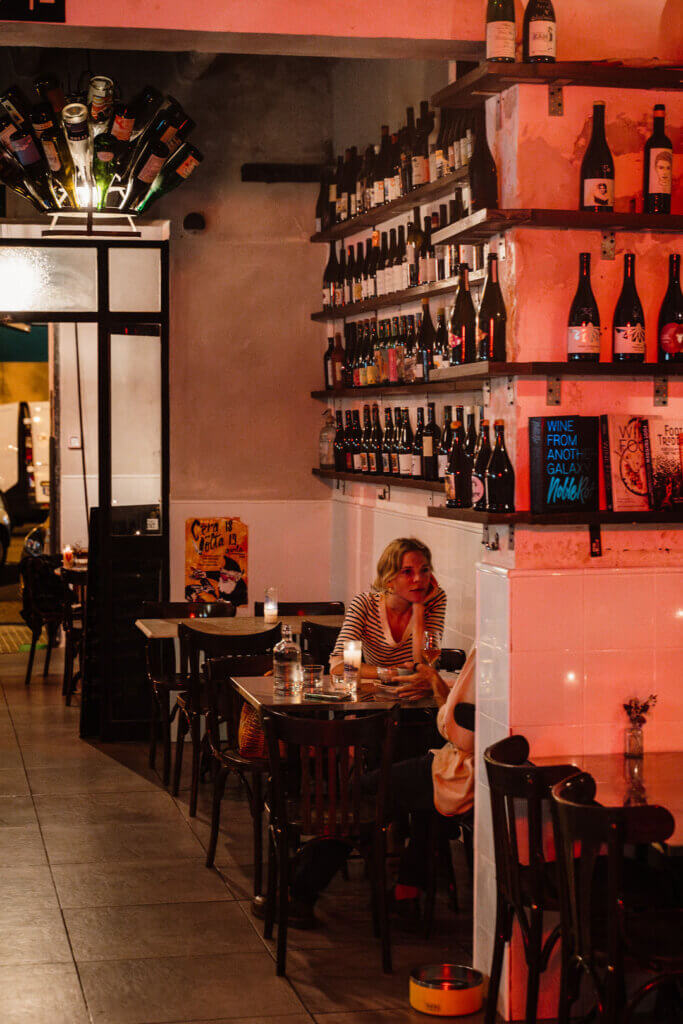 Interior of La Sang natural wine bar with red lighting and bottle shelves Palma Mallorca