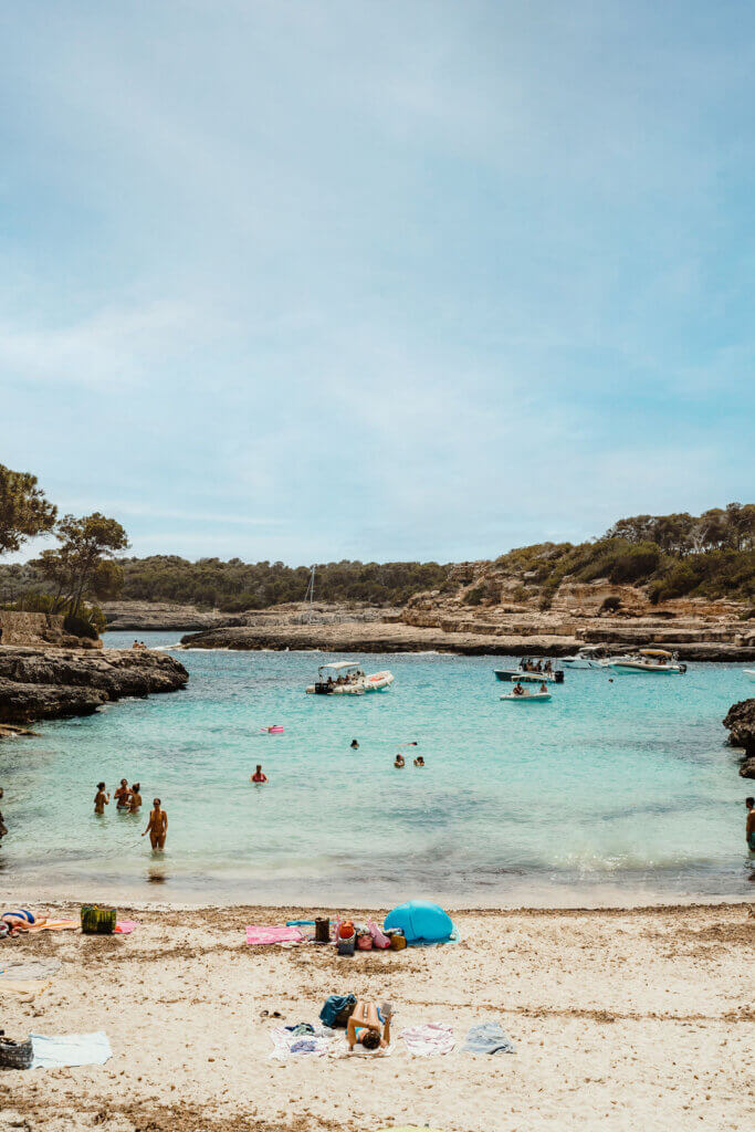 People swimming in clear turquoise water at a scenic Mallorca cala beach