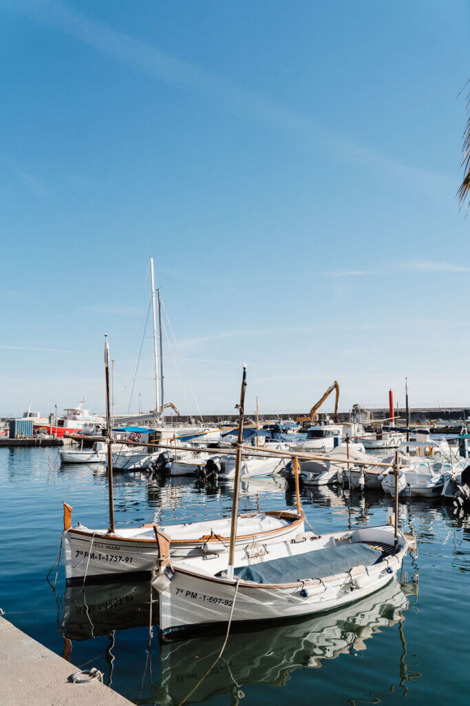 Traditional wooden llaut fishing boats in a sunny Mallorca harbor