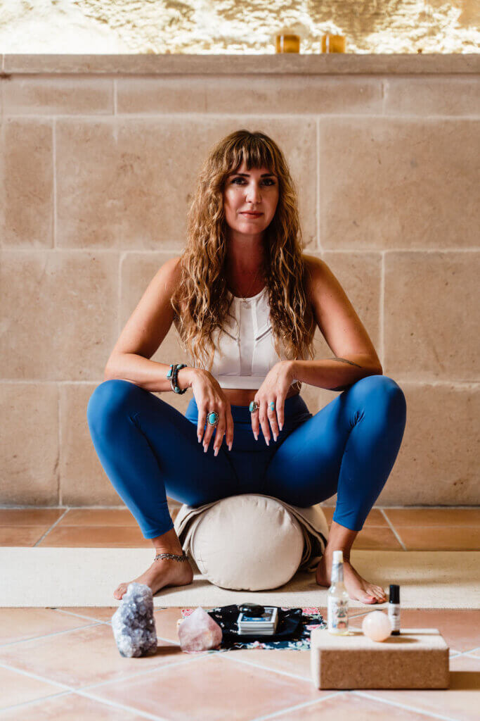 Woman sitting in yoga pose with tarot cards