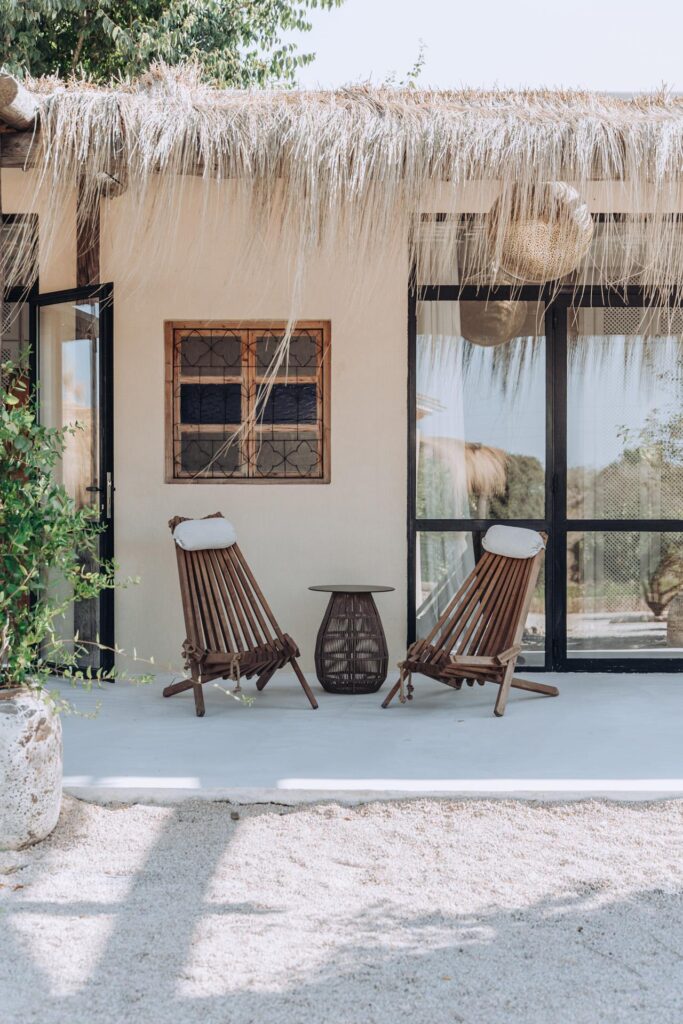 Wooden lounge chairs beneath a thatched roof at Finca Palmera.