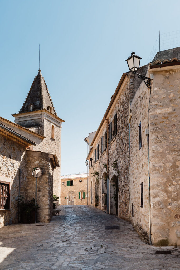Historic stone street and church tower in a Mallorca village.
