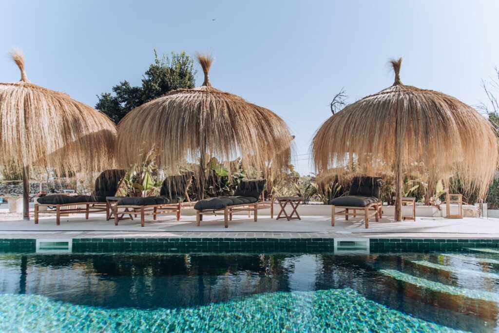 Thatched poolside umbrellas and loungers at Finca Palmera.