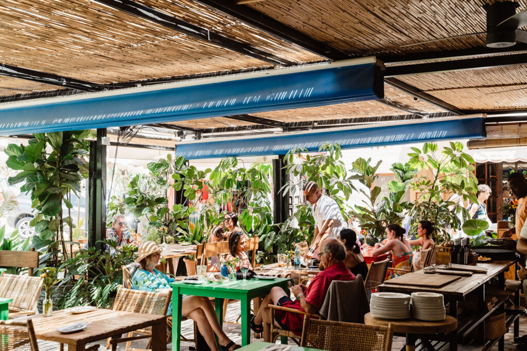 Sa Caleta Villa, Ibiza: diners seated beneath a shaded, plant-filled terrace at Mary Sal.