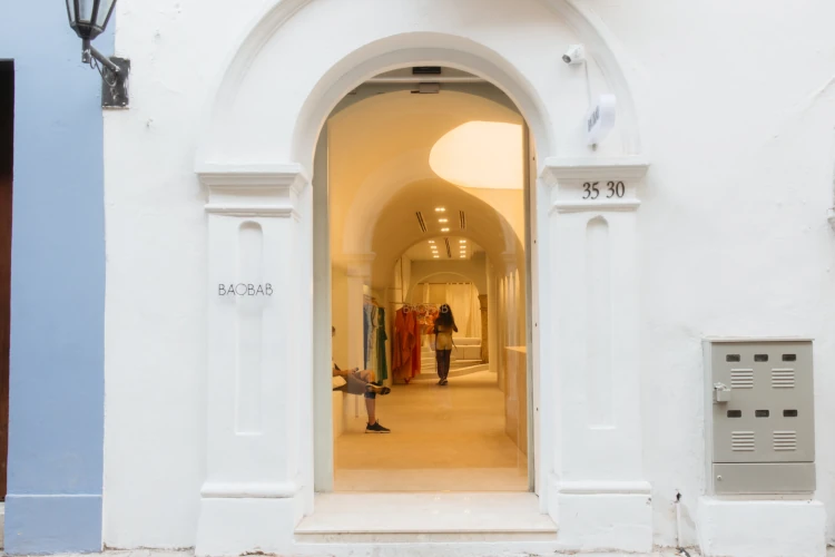 A white archway entrance to a boutique named 