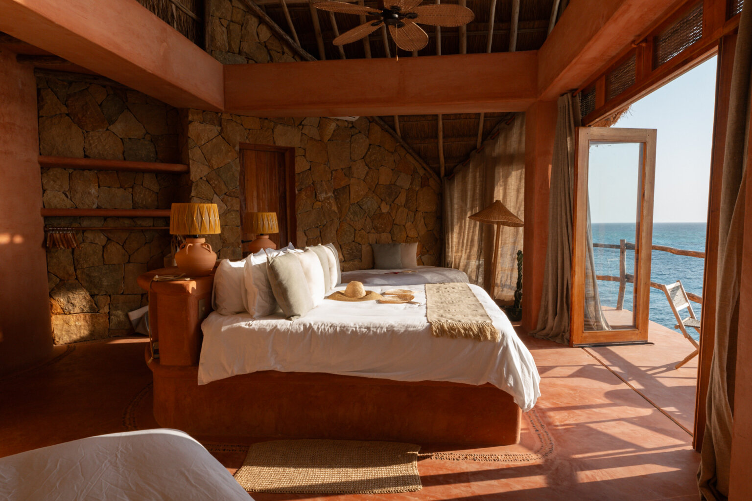 Open villa bedroom with bed facing the sea