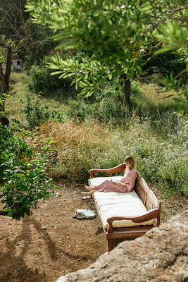 Woman relaxing on a daybed surrounded by trees and greenery in the Balearic Islands