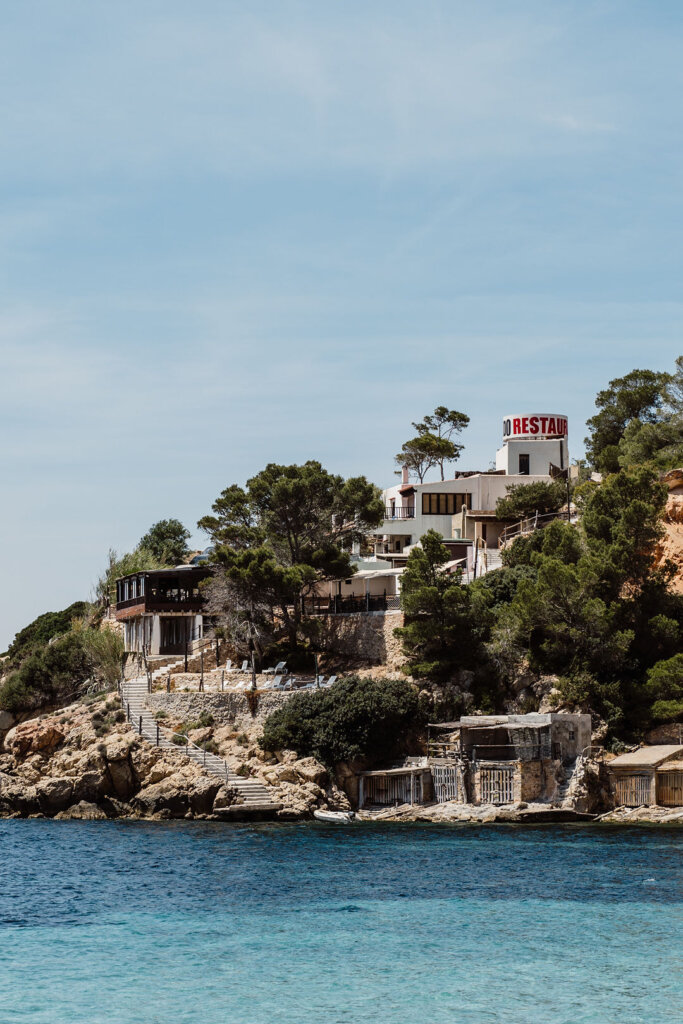 Cala d'Hort coastline with rocky shore and turquoise Mediterranean water in Ibiza