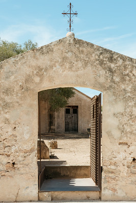 Historic stone doorway leading into a rustic courtyard in Ibiza