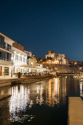 Waterfront buildings illuminated at night beside the water in Ibiza