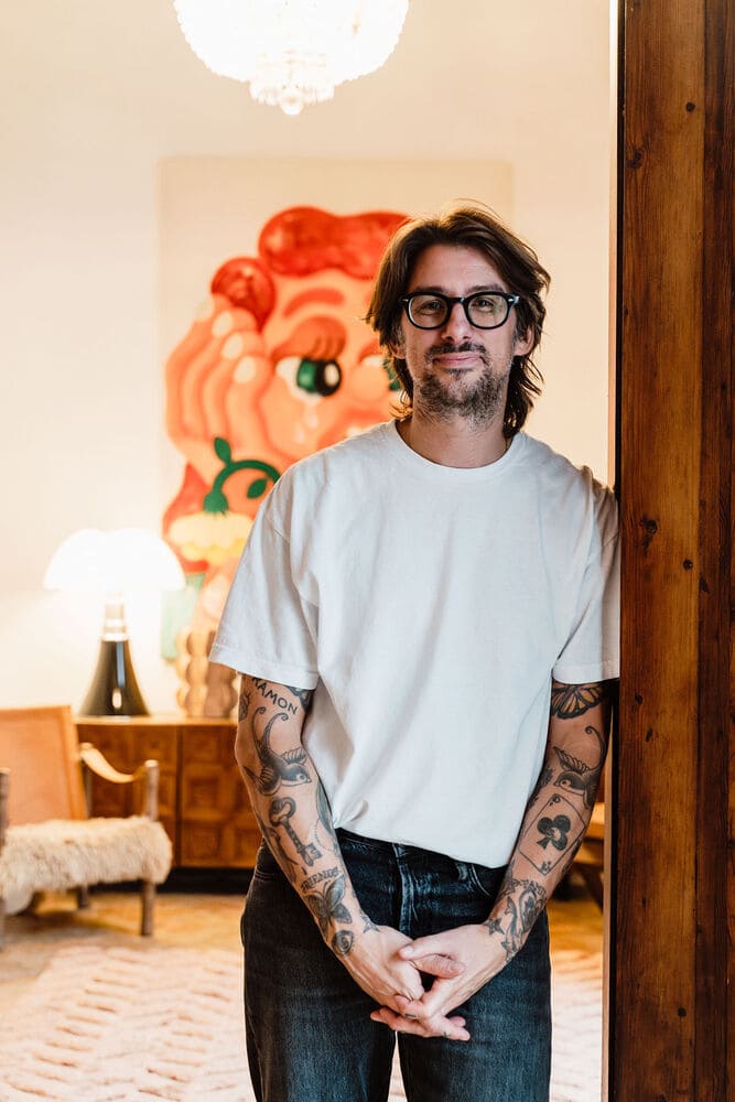 Man standing inside a Mallorca home surrounded by artwork and furniture