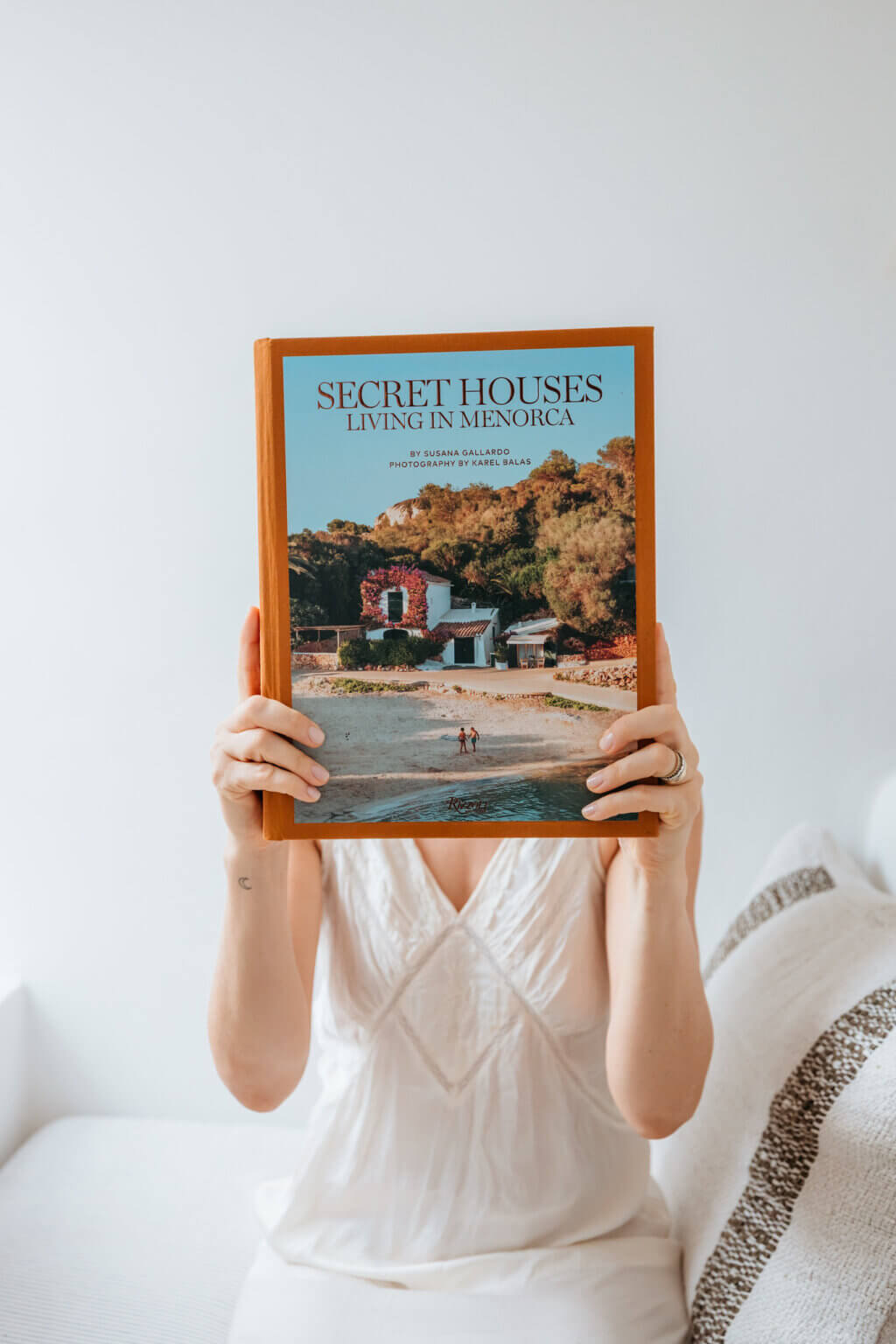 Woman holding a book about traditional houses in Menorca