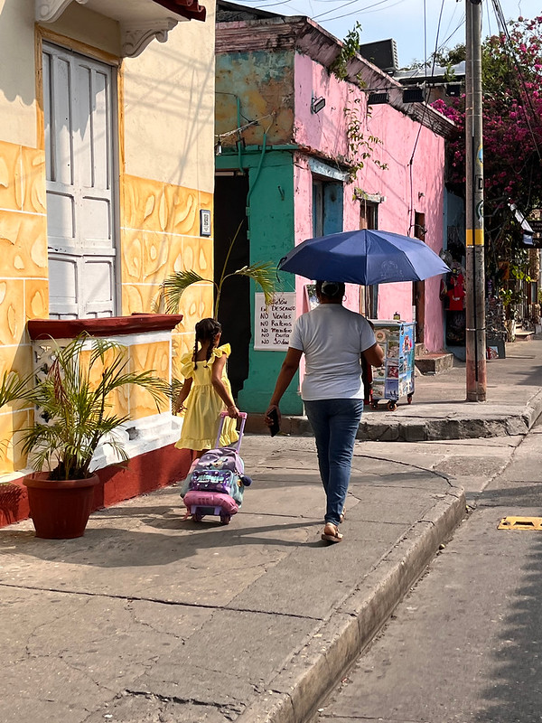 Woman and child walking through a colorful neighborhood in Cartagena, Colombia