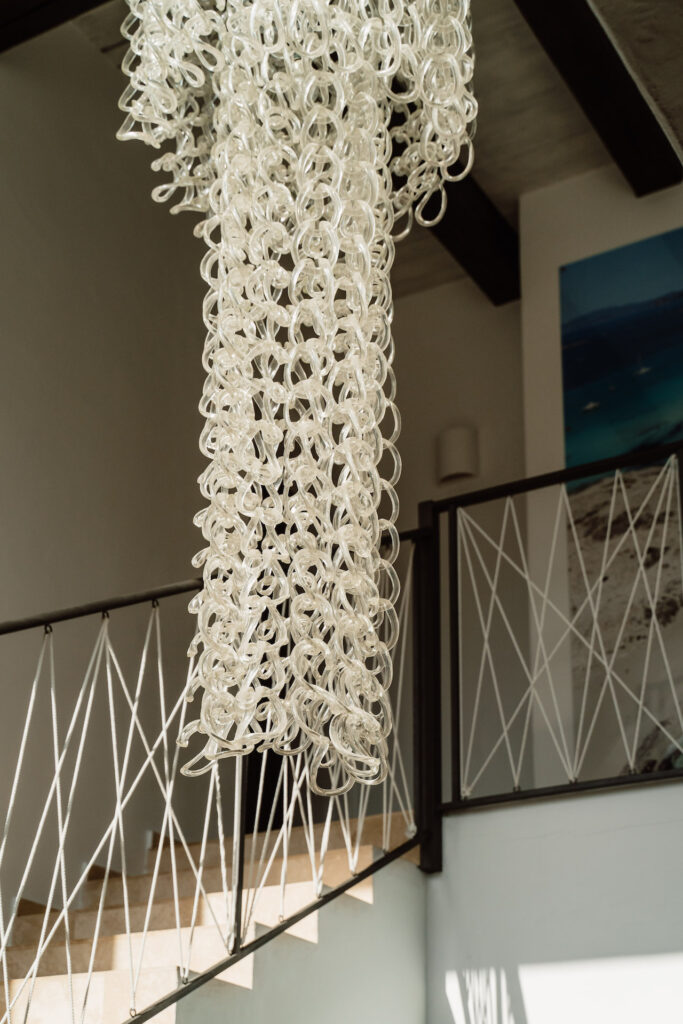 Sculptural glass pendant light above the staircase at Villa Lunara.