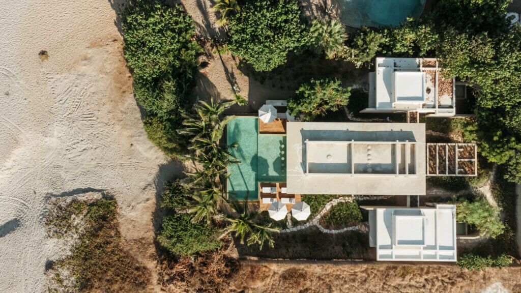 Aerial view of the villa, pools, and beachside grounds.