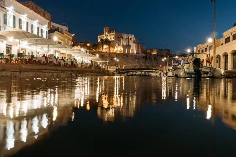 Night time by the harbour in Ciutadella with the cathedral lit up