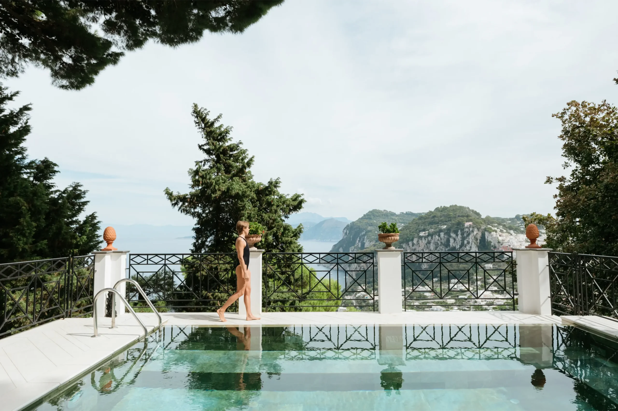 Marcia walking by the pool at Villa Anima in Capri, looking out at the sea