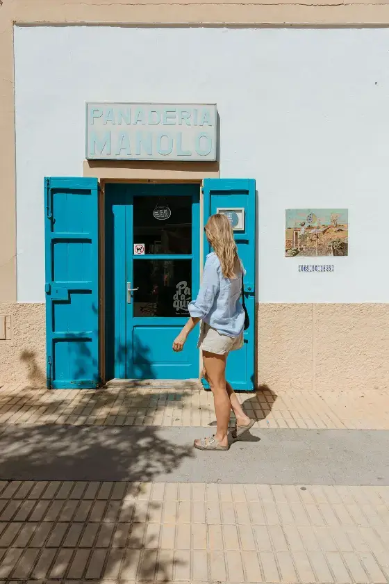 Woman walking into Panaderia Can Manolo in Sant Francesc, Formentera