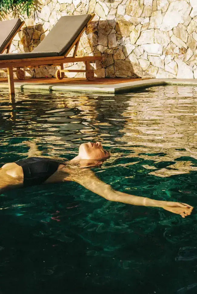 Woman floating in the swimming pool at Hacienda Oro Molido in Antioquia, Colombia