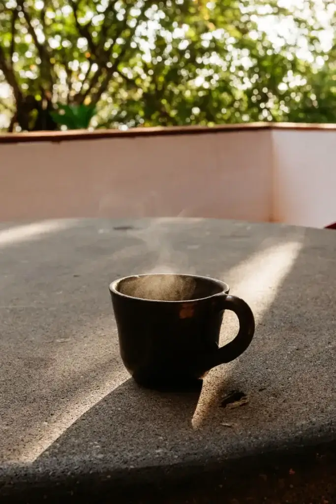 Steaming cup of coffee on a terrace in the morning sunlight at Casa Nahual