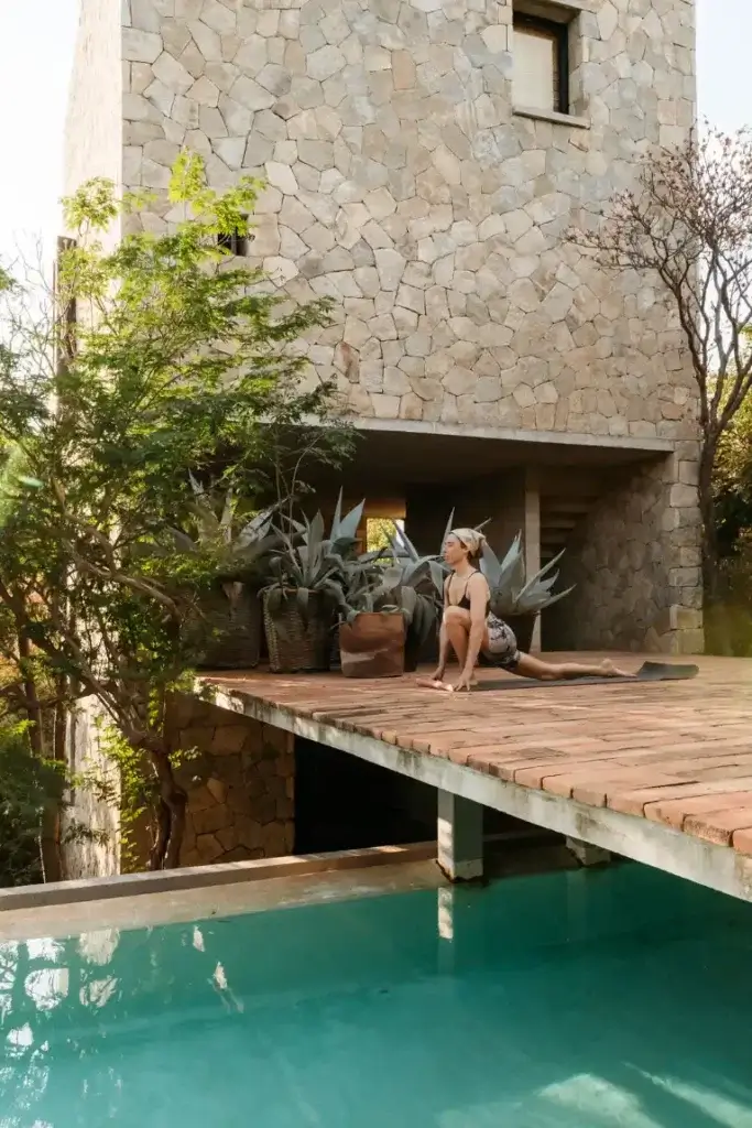 Woman practicing yoga beside the pool at Casa Nahual in Mazunte, Mexico