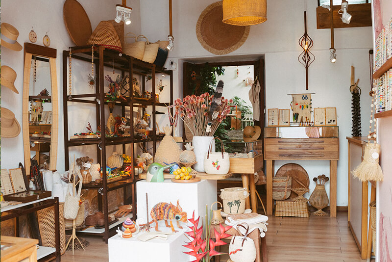 Interior of a local artisan craft shop in Barichara, Colombia, displaying handmade woven baskets, hats, jewelry, and traditional Colombian decor.