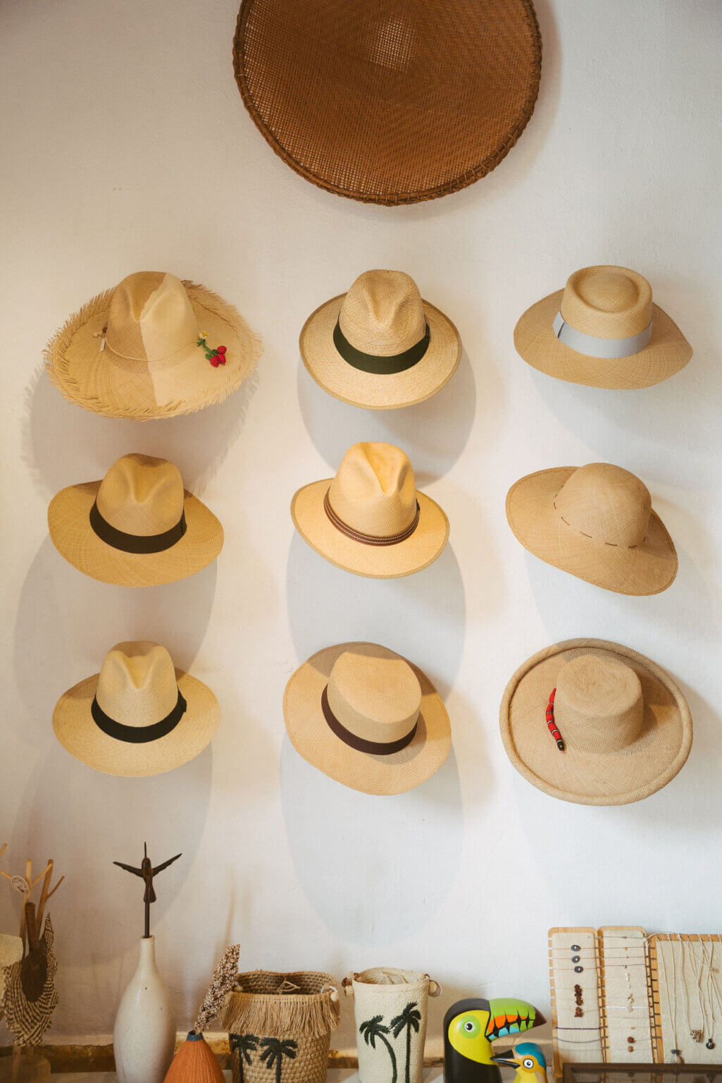 A wall display of traditional Colombian straw hats and handmade woven accessories at an artisan boutique in Barichara.
