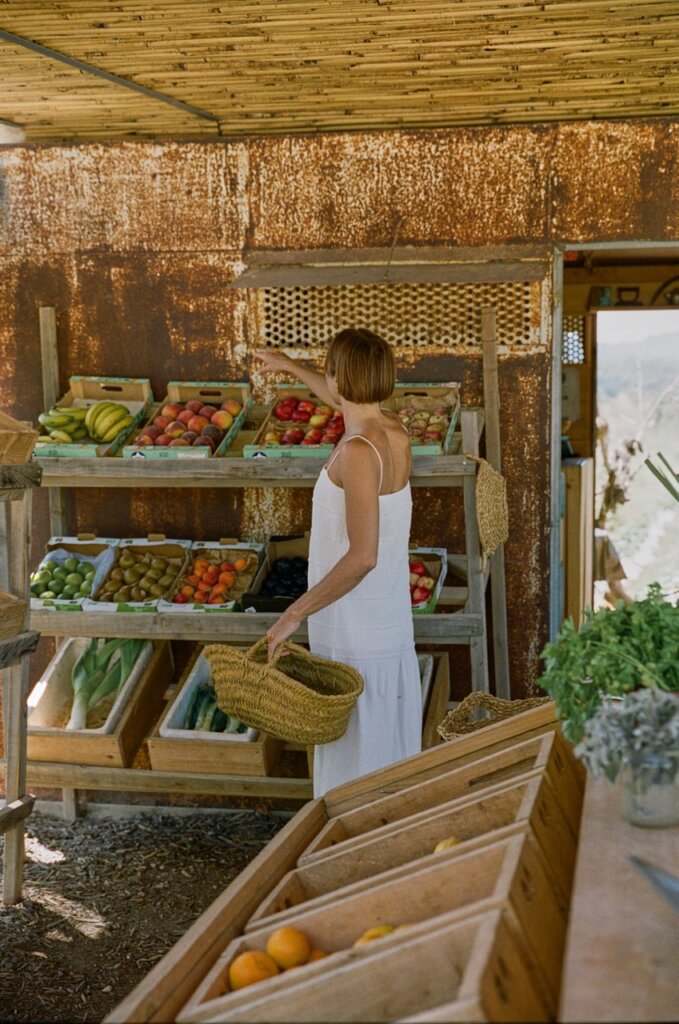 Shopper chooses fresh fruit at an open-air produce stall in Ibiza.