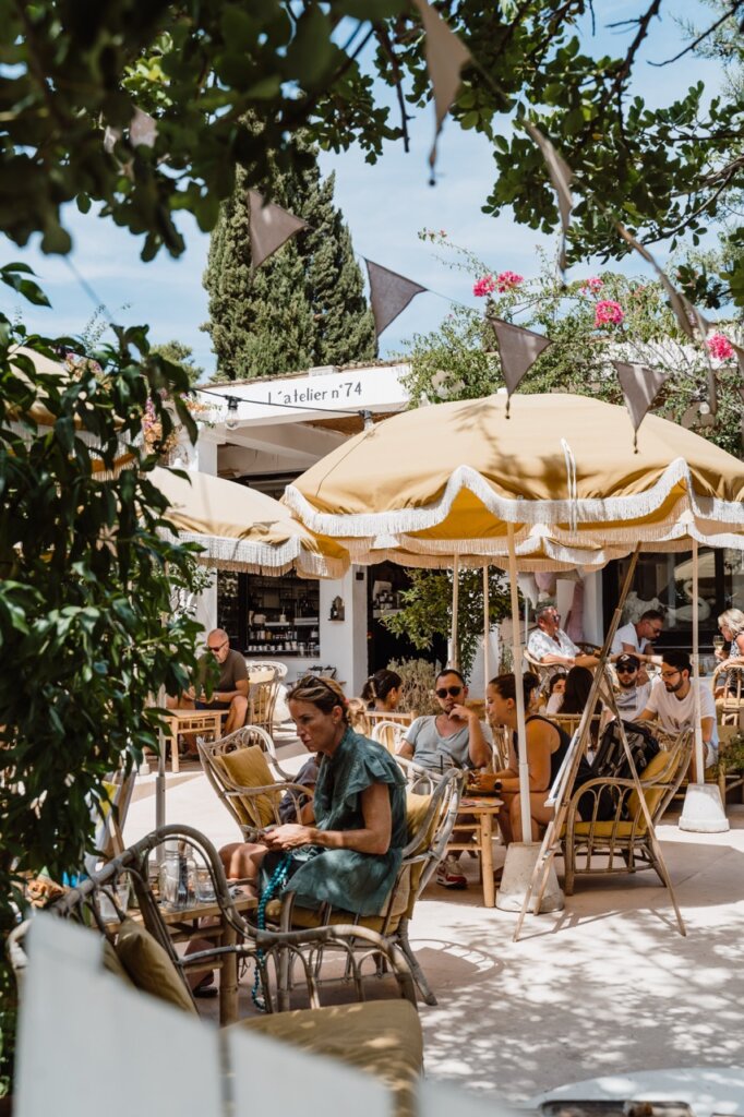 Diners beneath fringed umbrellas at a café terrace in Santa Gertrudis, Ibiza.