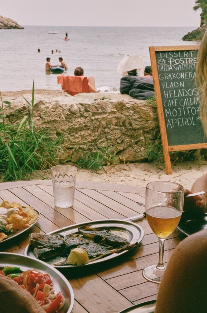 Fresh seafood lunch at a beachside table overlooking the calm waters of Ibiza.