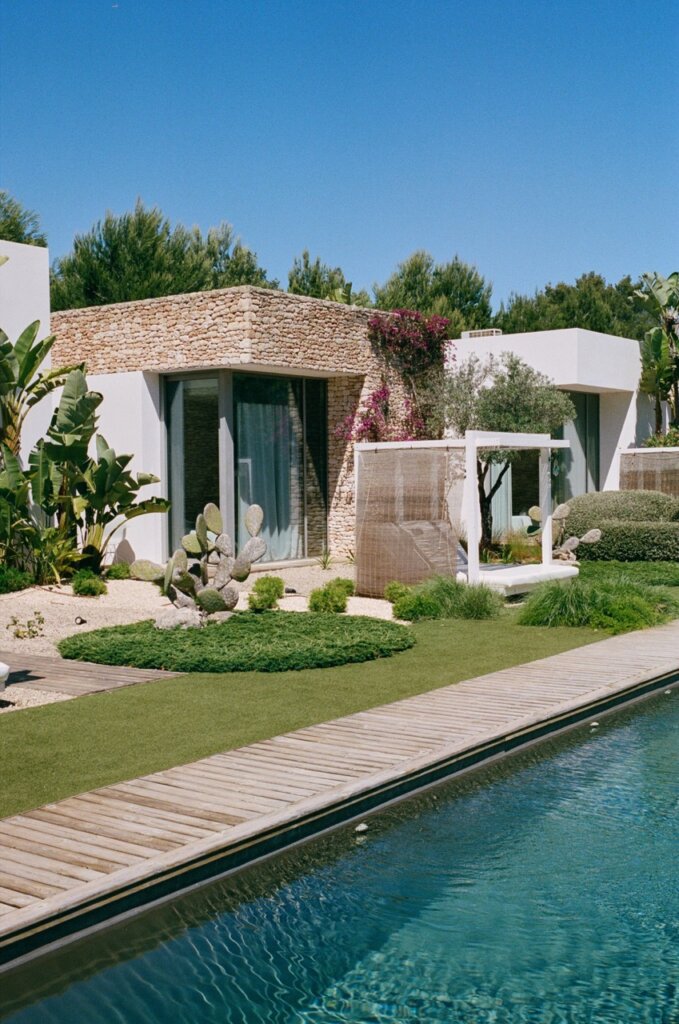 Private swimming pool with wooden decking and a shaded seating area at Can Paloma, Ibiza.