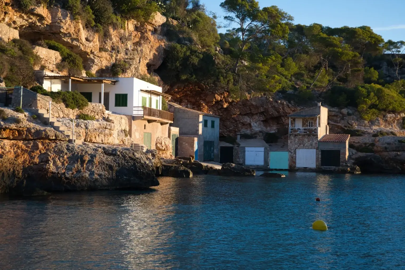 Cala Llombards with turquoise water, rocky cliffs and pine trees in Mallorca, Spain