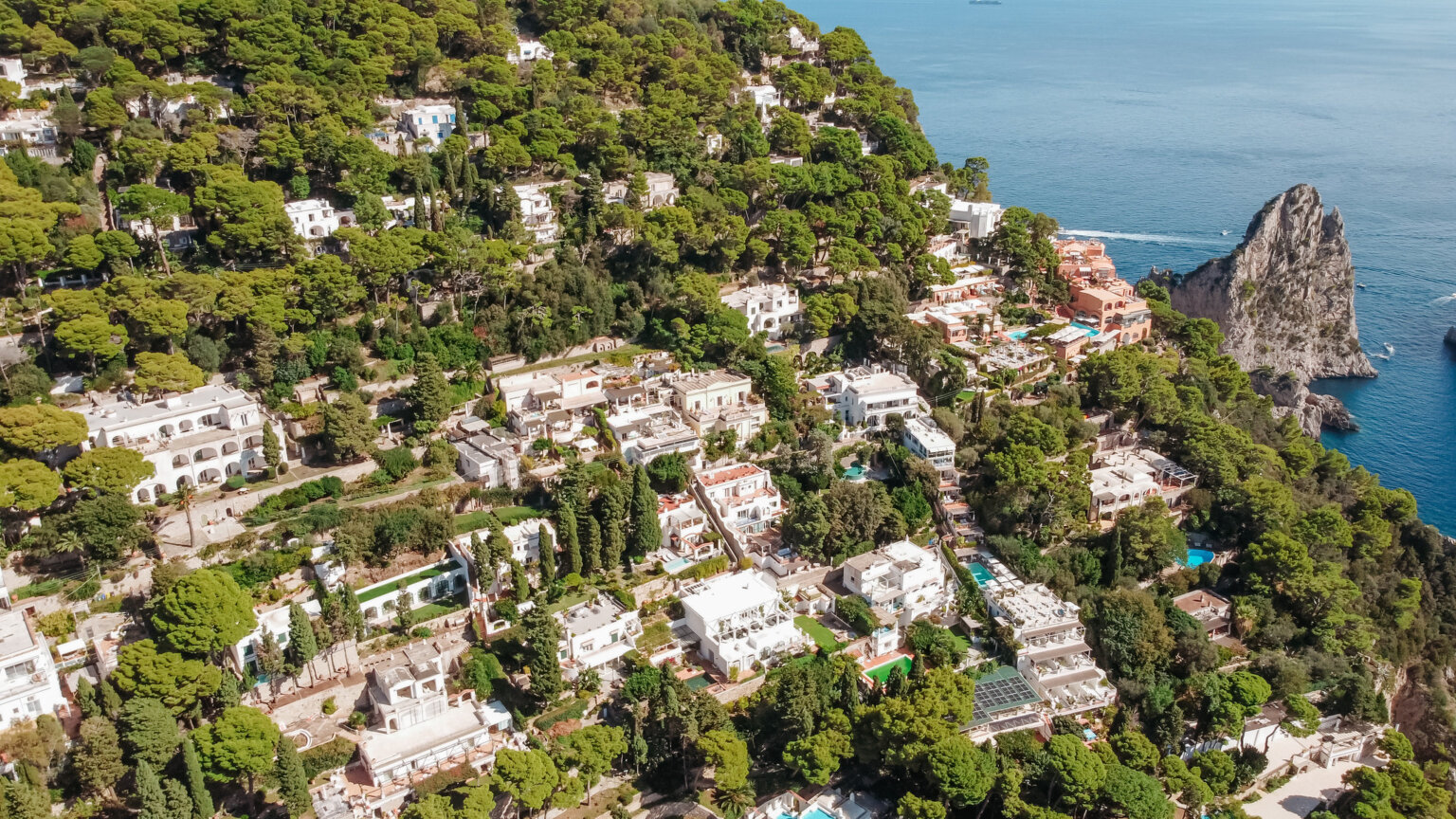Aerial view of Capri's coastline, hillside villas and the Faraglioni rocks