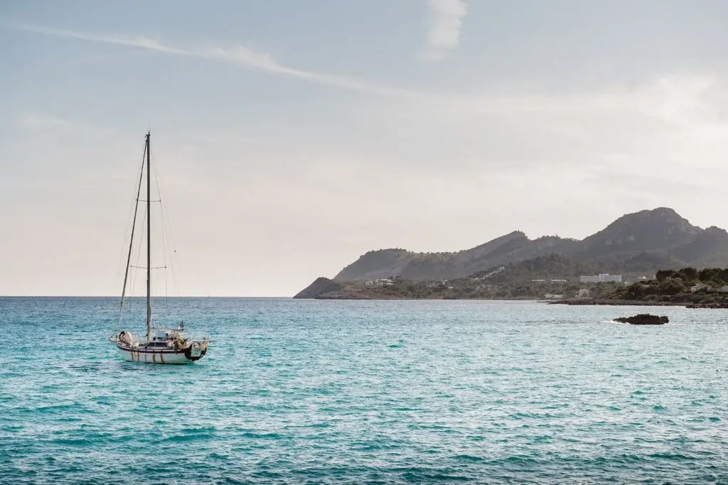 Turquoise Mediterranean cove surrounded by rocky cliffs and pine trees in Mallorca, Spain