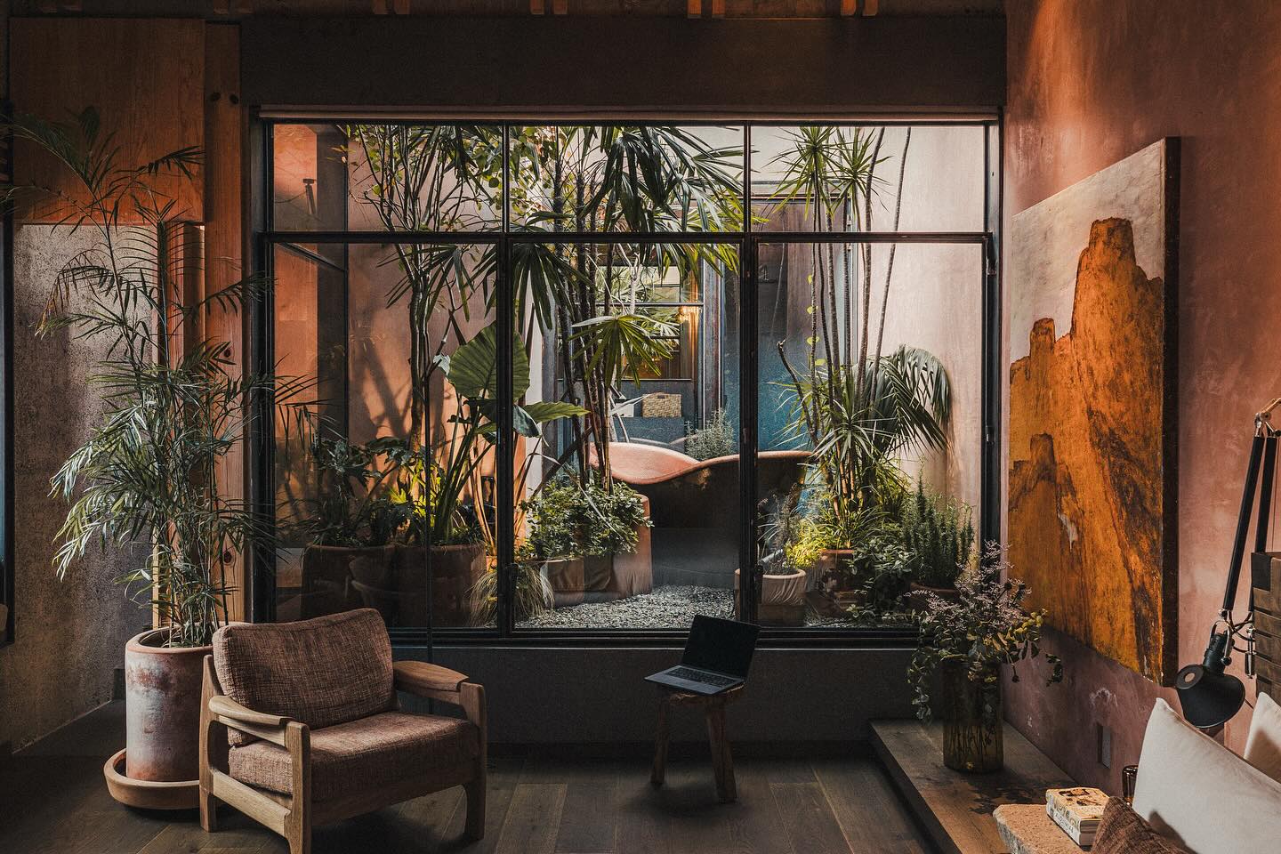 Stylish boutique hotel interior with tropical plants and a cozy seating area in Mexico City