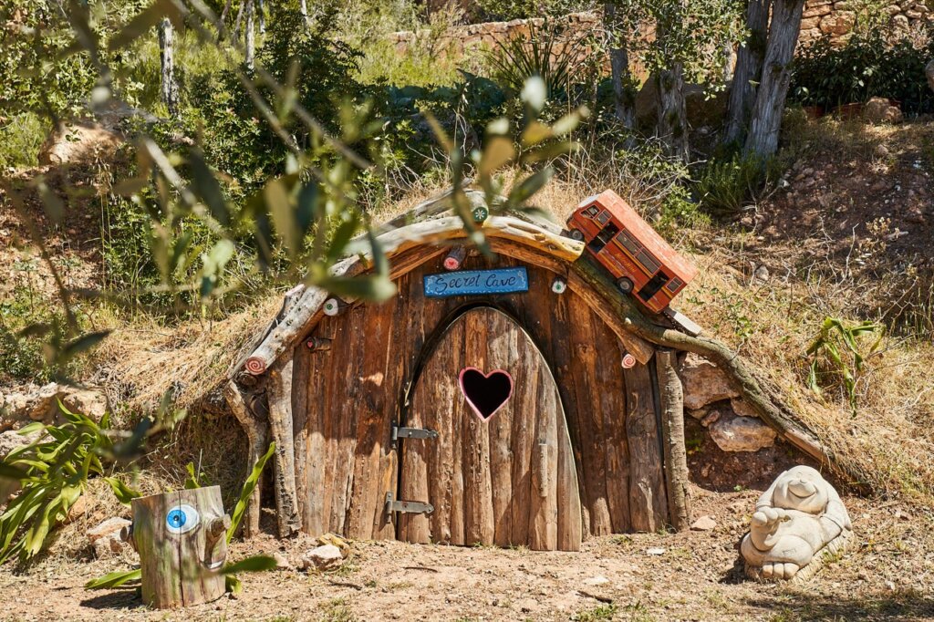 Woodland play area at Finca Delica in San Lorenzo, Ibiza, featuring a rustic wooden hideaway for children.