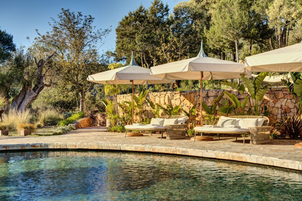 Poolside loungers beneath parasols at Fincadelica villa