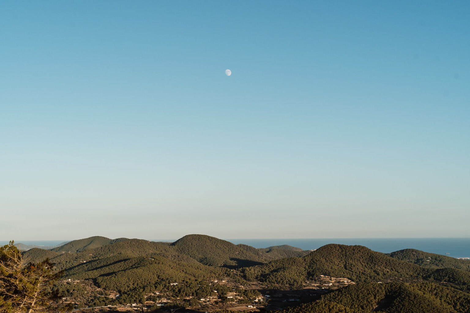 Moon above the forested hills and coastline of northern Ibiza.